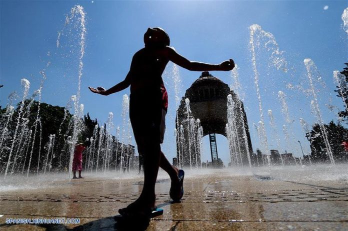 A youngster enjoys the fountains at the Monument to the Revolution in Mexico City.