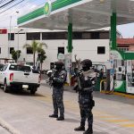 Police stand guard at a BP gas station in Puebla.