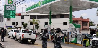Police stand guard at a BP gas station in Puebla.