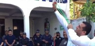 The mayor demonstrates the use of a slingshot in front of disarmed police.