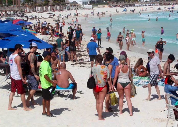 Tourists enjoy the beach in Cancún.