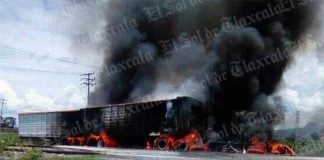 Truck burns after Saturday's collision with a train.