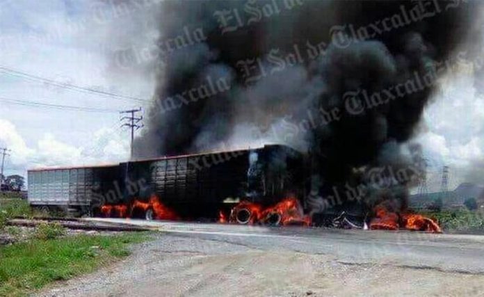 Truck burns after Saturday's collision with a train.