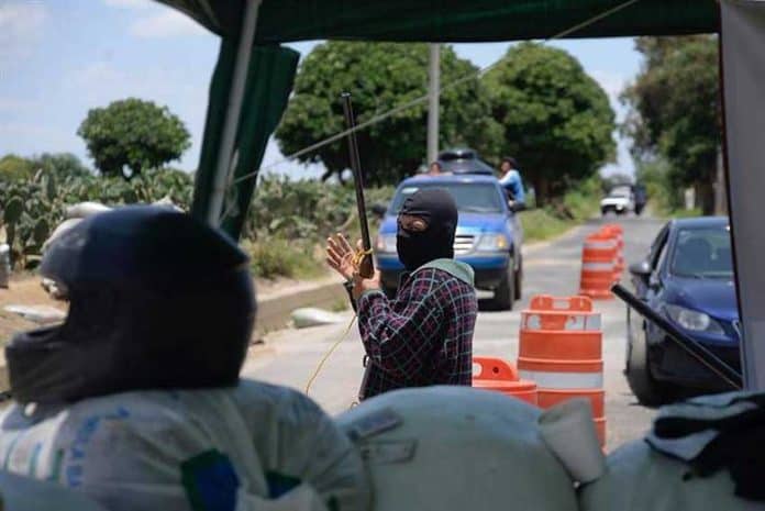 A self-defense force guard mans a Morelos checkpoint.