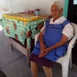 Jalisco's oldest woman sells candy on the sidewalk outside her home.