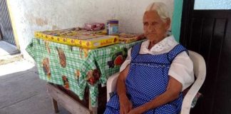 Jalisco's oldest woman sells candy on the sidewalk outside her home.
