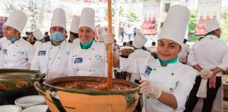 A chef stirs a pot of mole sauce during Oaxaca festival.