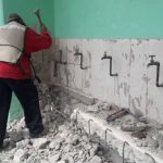 A worker carries out repairs at a school damaged by earthquakes.