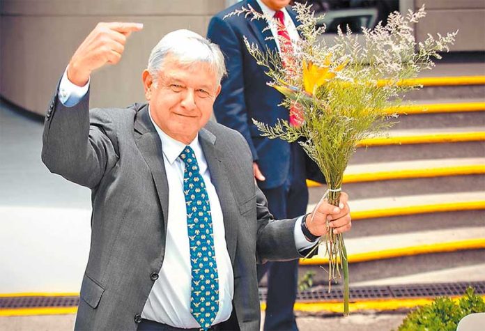López Obrador greets supporters, who presented him with a bouquet of flowers, after yesterday's ceremony.