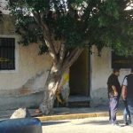 Investigators outside the house where bodies were buried.
