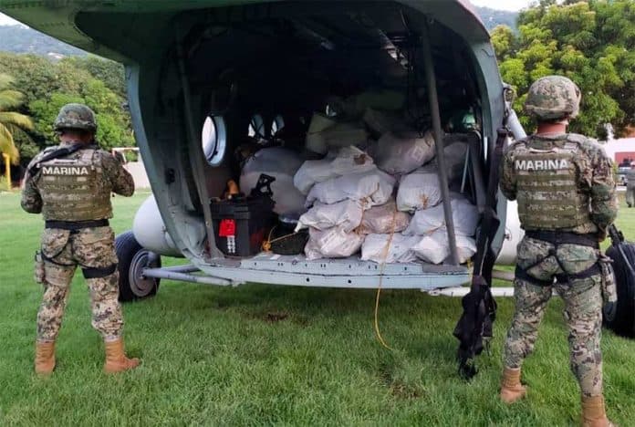 Marines guard packages of white powder seized yesterday from a boat in Guerrero.