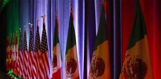 The national flags of Canada, the U.S. and Mexico are lit by stage lights before a news conference at the start of NAFTA renegotiations in Washington