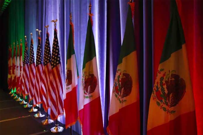 The national flags of Canada, the U.S. and Mexico are lit by stage lights before a news conference at the start of NAFTA renegotiations in Washington