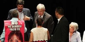 José Luis Castillo at yesterday's forum wearing his canvas sign that bears a photo of his missing daughter.
