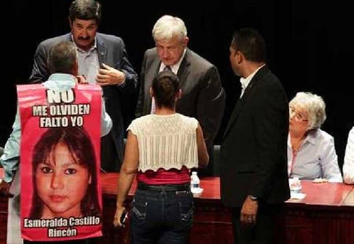 José Luis Castillo at yesterday's forum wearing his canvas sign that bears a photo of his missing daughter.