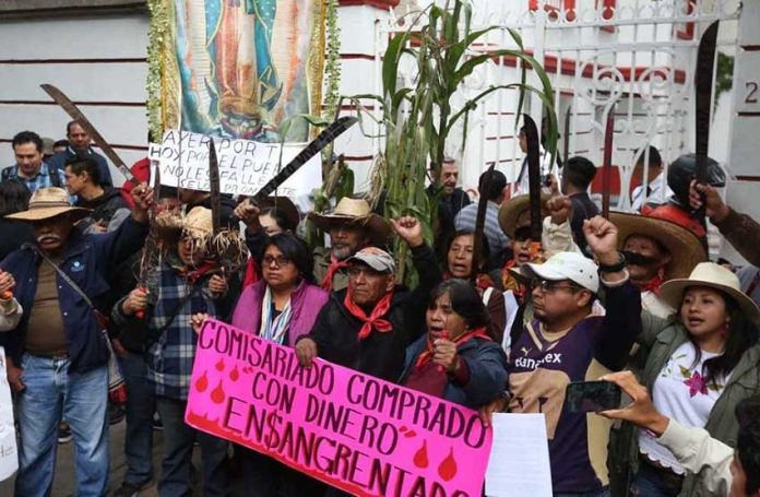 Airport protesters raise their machetes in defiance against the project.