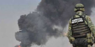 A soldier watches as a fire burns at a tap on the Tula-Salamanca pipeline in Guanajuato.