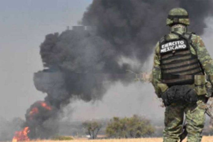 A soldier watches as a fire burns at a tap on the Tula-Salamanca pipeline in Guanajuato.