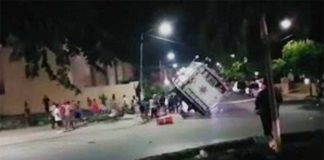 Residents push over a mobile police unit in Playa del Carmen last night.