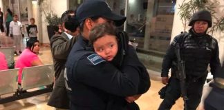 Mya Fernanada in the arms of a police officer after her rescue yesterday.
