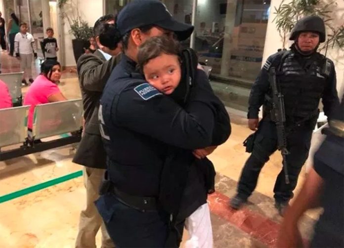 Mya Fernanada in the arms of a police officer after her rescue yesterday.