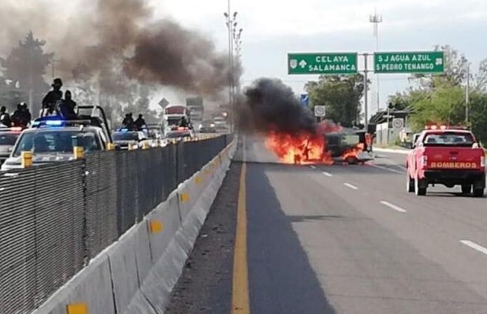 A vehicle burns yesterday in Guanajuato, set on fire by fleeing gangsters.