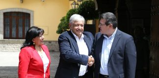 López Obrador, center, shakes on agreement with Tlaxcala Governor Mena.