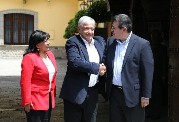 López Obrador, center, shakes on agreement with Tlaxcala Governor Mena.