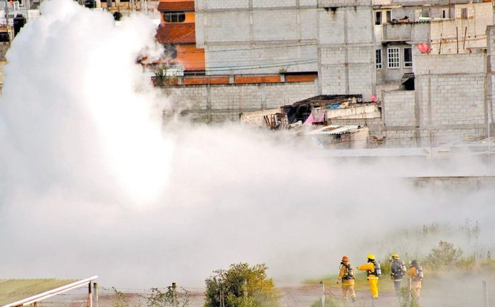 Firefighters and a cloud of gas yesterday in Puebla.