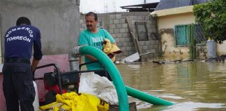 A Torreón firefighter mans a pump to remove floodwaters.