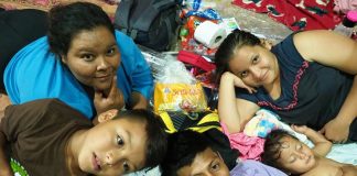 A family poses in their makeshift beds for the night in Arriaga.