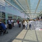 Protesters carry a banner calling for payment of money owed to communal landowners.