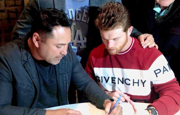 Boxer Álvarez, right, signs his new contract.