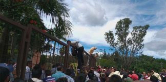 Workers scale a fence in an attempt to flee their captors.