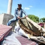 A Culiacán man shows his used mattress with the cover removed. One resident said they weren't fit for dogs to sleep on.