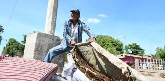 A Culiacán man shows his used mattress with the cover removed. One resident said they weren't fit for dogs to sleep on.