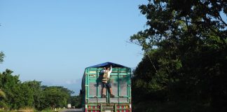 A migrant clings to the back of a truck in southern Mexico.
