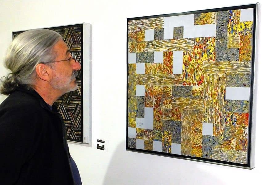 A visitor views the “hybrid” art of Alejandro Brambila.