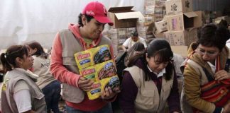 Volunteers hand out food as part of federal anti-hunger program.