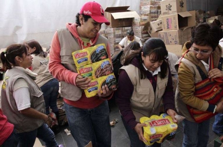 Volunteers hand out food as part of federal anti-hunger program.