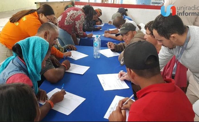 Central American migrants complete documents at Tijuana job fair.