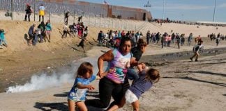A widely shared photo of a Honduran family fleeing the tear gas at the US border on Sunday
