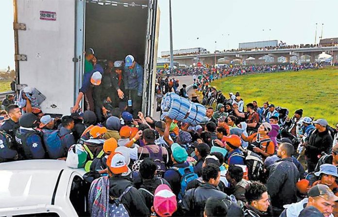 All aboard: migrants wait to climb into truck on their journey north.