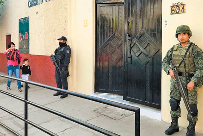 A police officer and a soldier stand guard at a Guerrero school.
