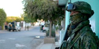 A soldier stands guard after a confrontation in a Mexican street.