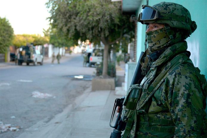 A soldier stands guard after a confrontation in a Mexican street.