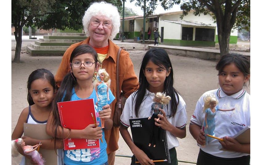 Geri de Moss, California retiree, with four schoolgirls.