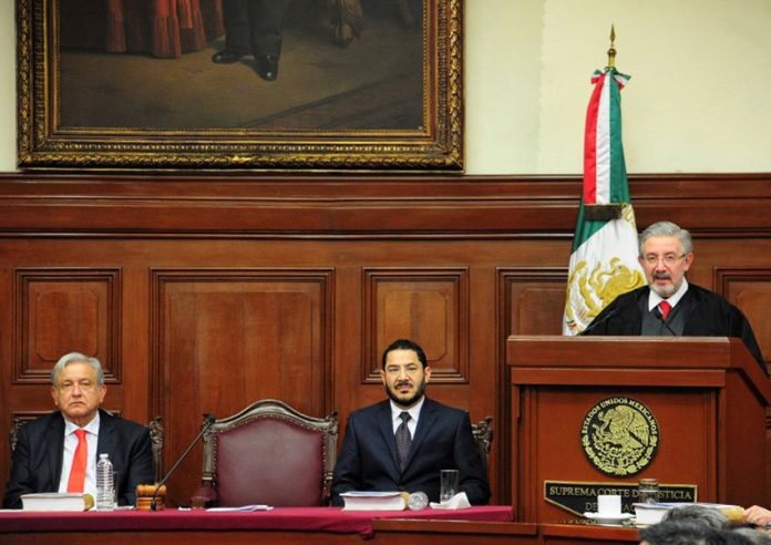 López Obrador and Morena party Deputy Martí Batres listen as Supreme Court justice Aguilar gives his address.