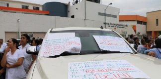 Health care workers surround the vehicle belonging to the governor's wife.