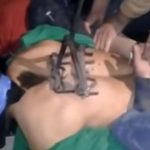 A suspected thief is branded on his back.